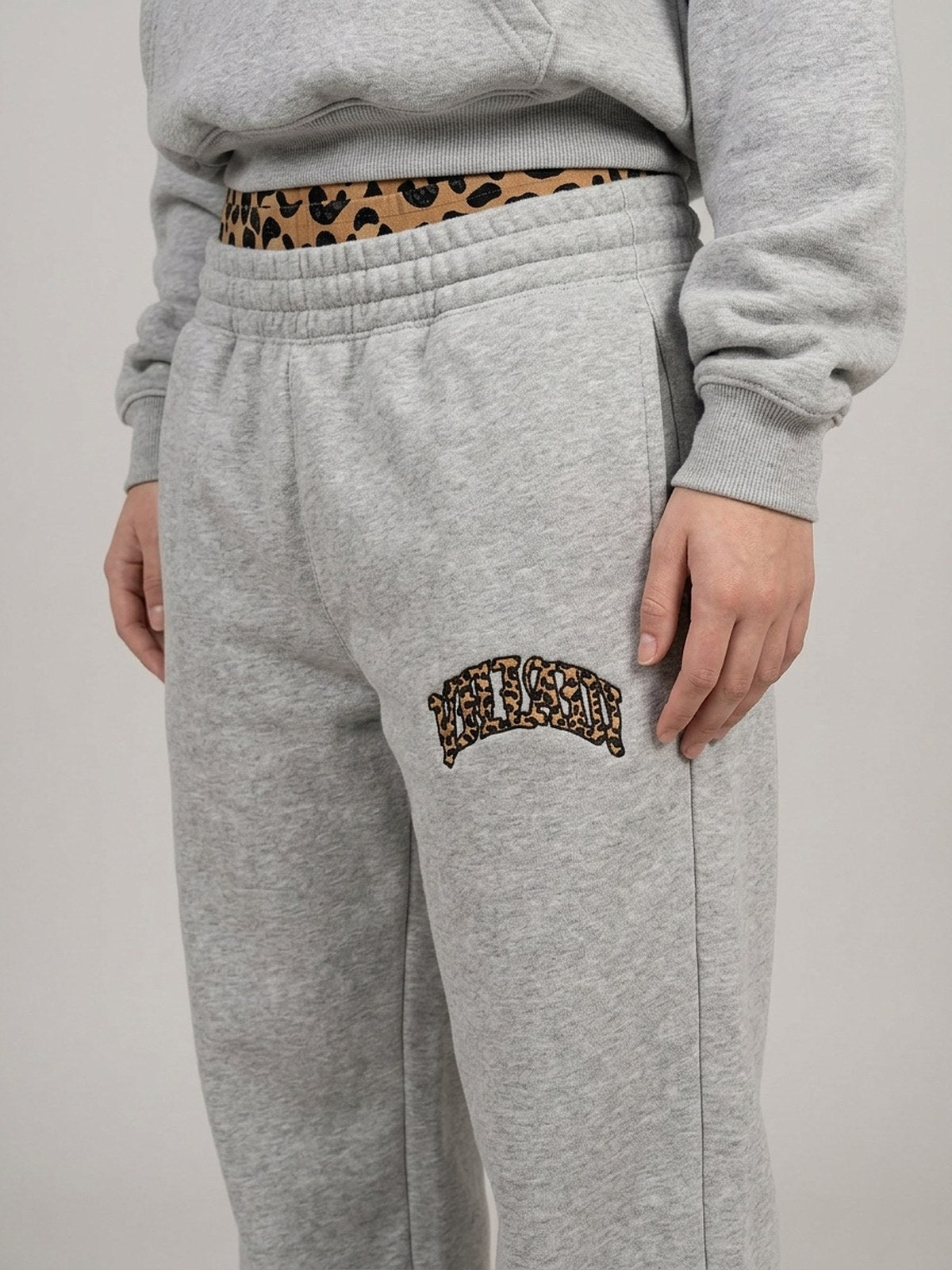 Ensemble NUVORI gris chiné — gros plan du logo cuisse